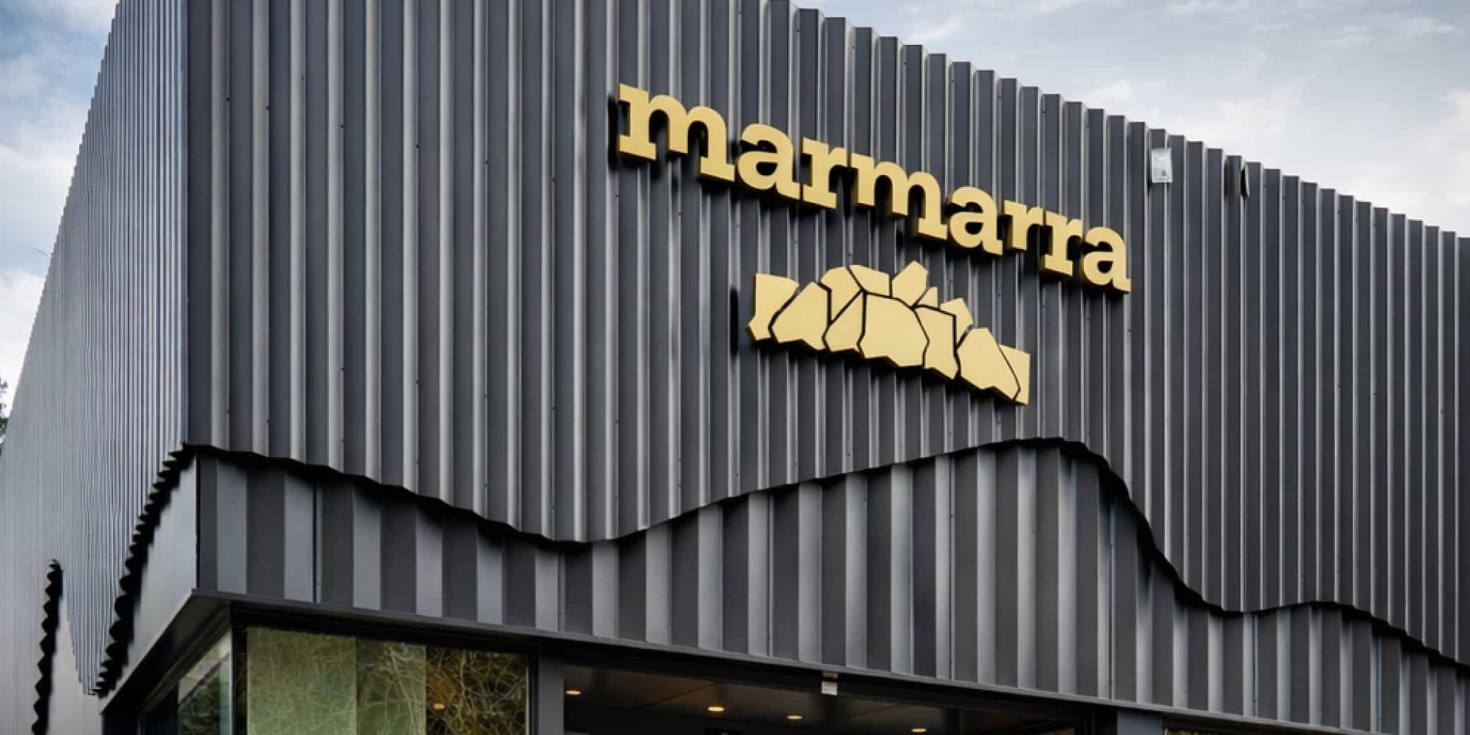 Imagen exterior de la fachada met&aacute;lica con el r&oacute;tulo &ldquo;marmarra&rdquo; y la entrada acristalada del edificio, ideal para contextualizar la ubicaci&oacute;n y el acceso.