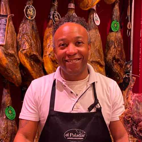Vlado. Dependiente en El Paladar, Jamonería & Delicatessen (Palma). Vlado es un amable dependiente en El Paladar, Jamonería & Delicatessen en Palma. Su paciencia y buen hacer son sus mayores virtudes, siempre brindando un servicio excepcional a nuestros clientes. Con un espíritu cubano tranquilo y calmado, Vlado contagia su risa y alegría a todos los que lo rodean.
Como dependiente, Vlado se destaca por su atención personalizada, asesorando a los clientes y guiándolos a través de nuestra amplia selección de productos. Su conocimiento en jamones y productos delicatessen es impresionante, lo que le permite ofrecer recomendaciones acertadas.
Además de ser un experto en su trabajo, Vlado es conocido por su carisma y su capacidad para crear un ambiente acogedor en la tienda. Su risa es contagiosa y añade un toque de alegría a la experiencia de compra de nuestros clientes. Con Vlado como parte de nuestro equipo, nuestros clientes pueden esperar un trato cálido y una atención excepcional.